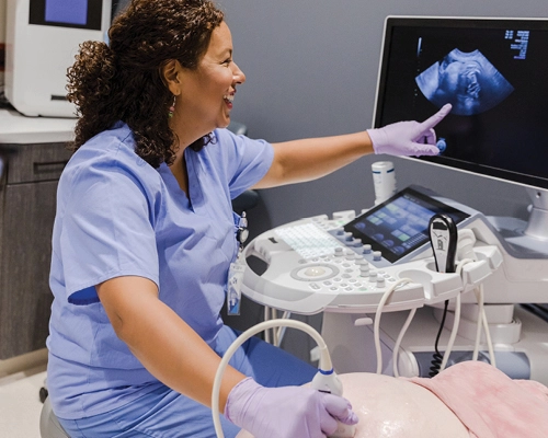 Provider performing ultrasound on pregnant patient